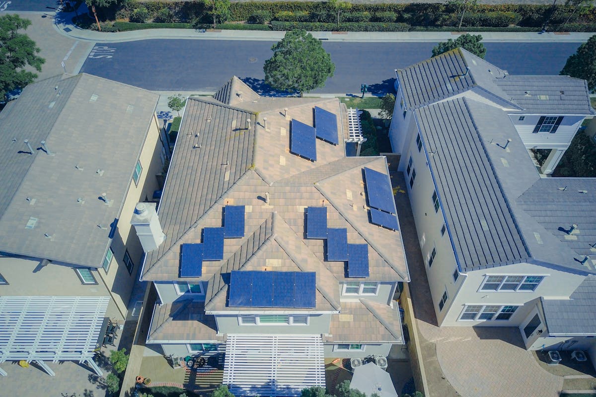 Aerial view of suburban homes equipped with solar panels in a sunny neighborhood